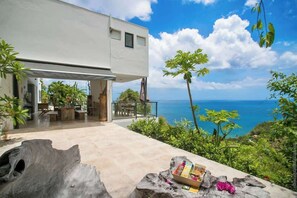 Une maison moderne dotée d’un patio offrant une vue panoramique sur l’océan.