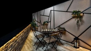 A modern interior with geometric wall design, wooden furniture, and potted plants. - One Luxury Suites (Belgrade)