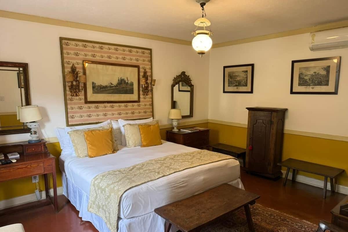 Une chambre à coucher avec un grand lit, des tables de chevet, un bureau, une chaise et une armoire.