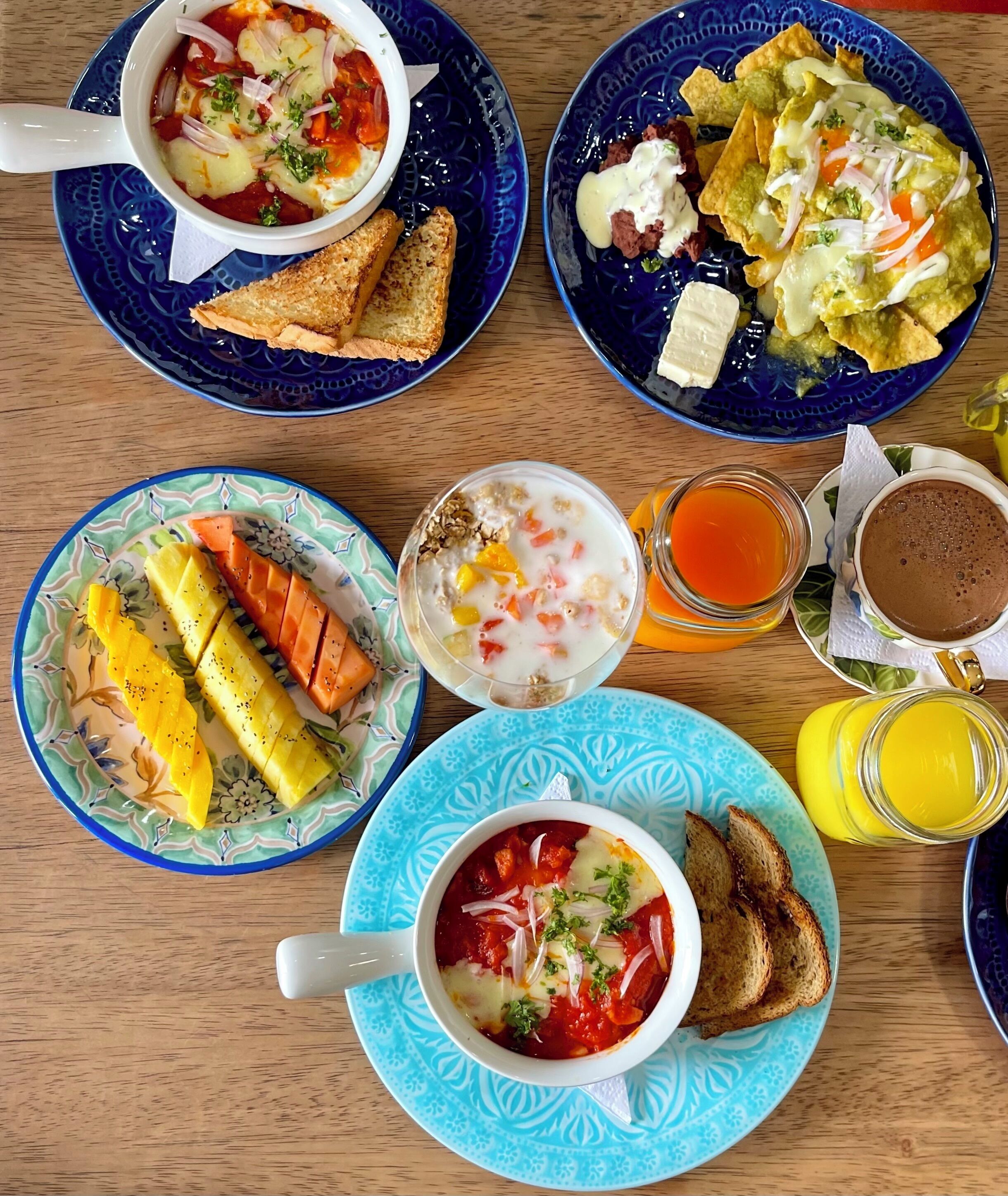 A breakfast setting with various dishes including soup, toast, and fruit.
