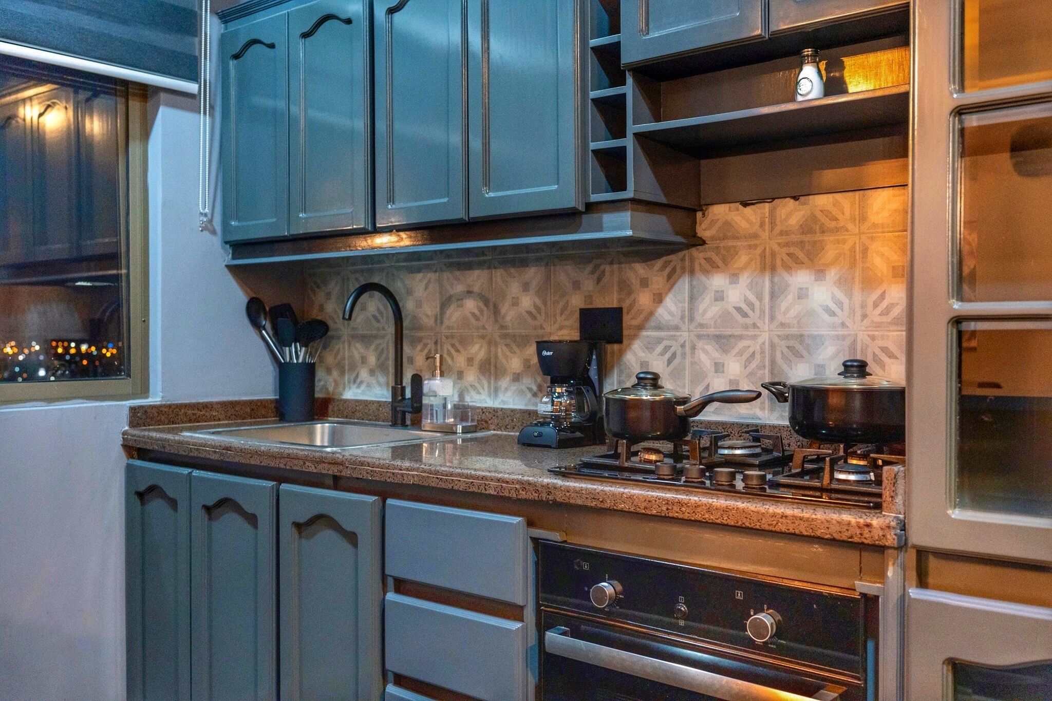 Una cocina moderna con encimeras de granito, electrodomésticos de acero inoxidable y un salpicadero con diseño.