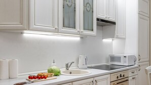 A modern kitchen with white cabinetry, a stainless steel oven, and a microwave. - Comfortable apartments in Minsk's Mayak (Minsk)