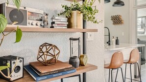 Eine Küche mit Holzböden, einem Radio, Büchern, einer Kamera und einer hängenden Pflanze.