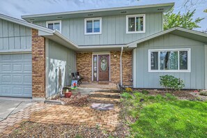 A two-story house with a brick facade, a front porch, and a garage. - Pet + Family Friendly | Office | 30 Day | Longmont (Longmont)