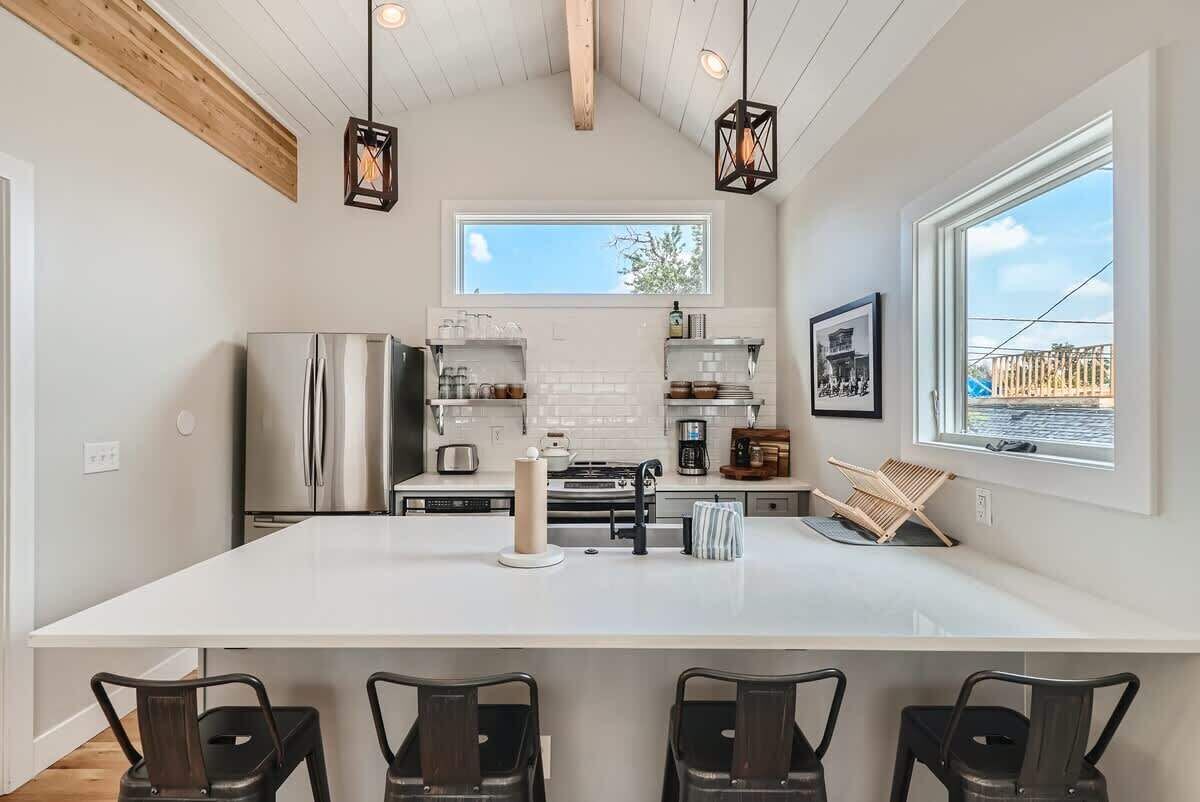 Una cocina moderna con una isla grande, electrodomésticos de acero inoxidable y vistas al exterior.