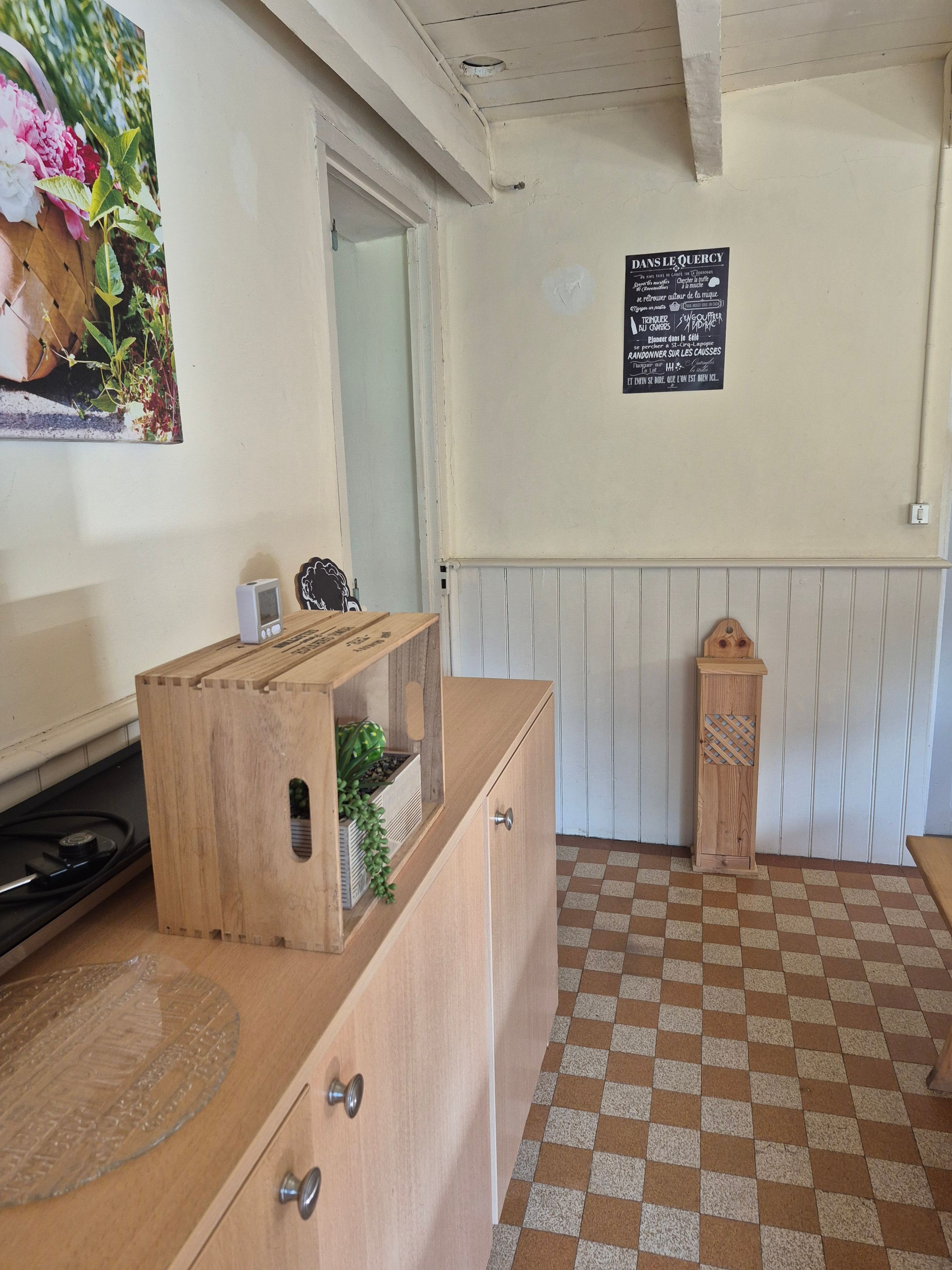 A kitchen with a wooden counter, a stove, and a checkered floor.