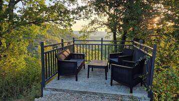 An outdoor seating area with a view of a mountainous landscape.