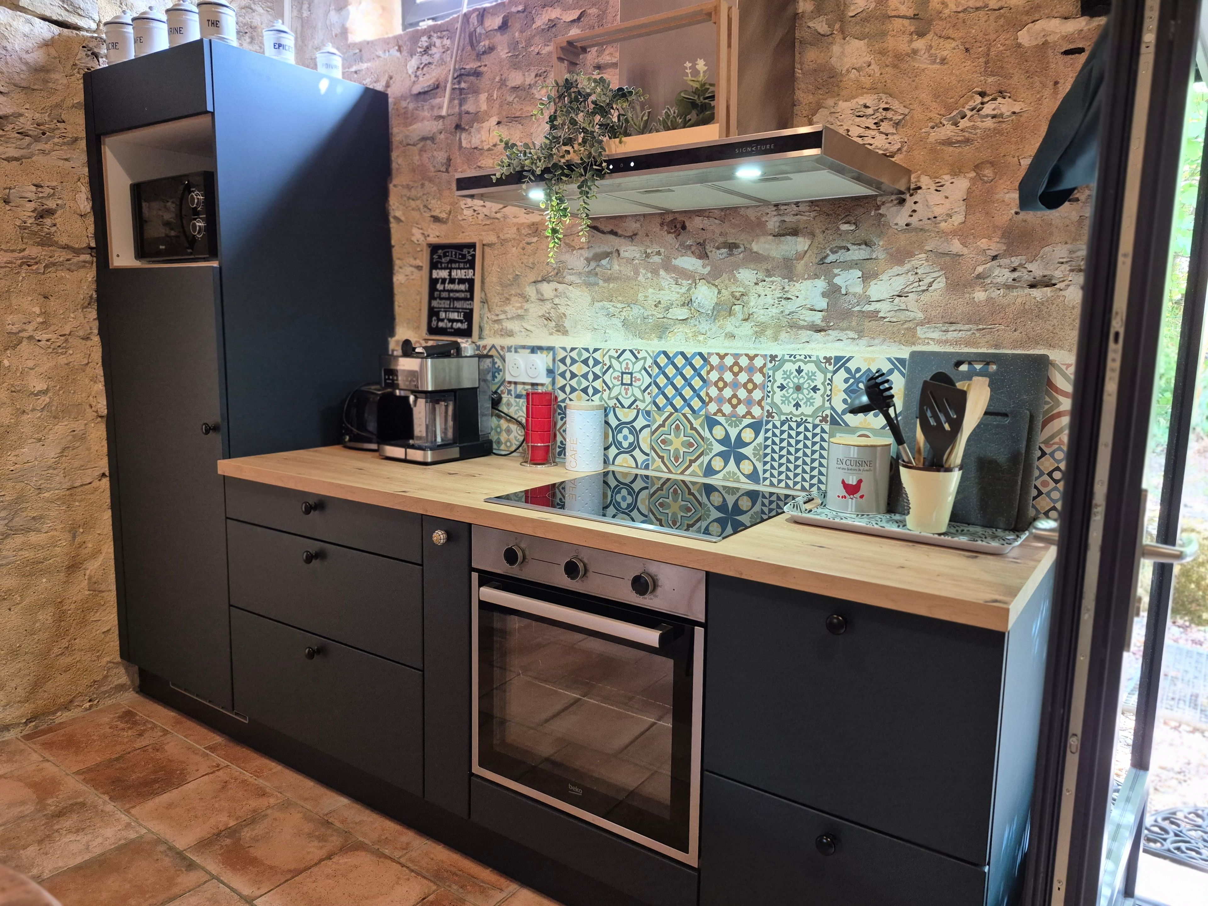 Uma cozinha com forno embutido, máquina de café e pia.