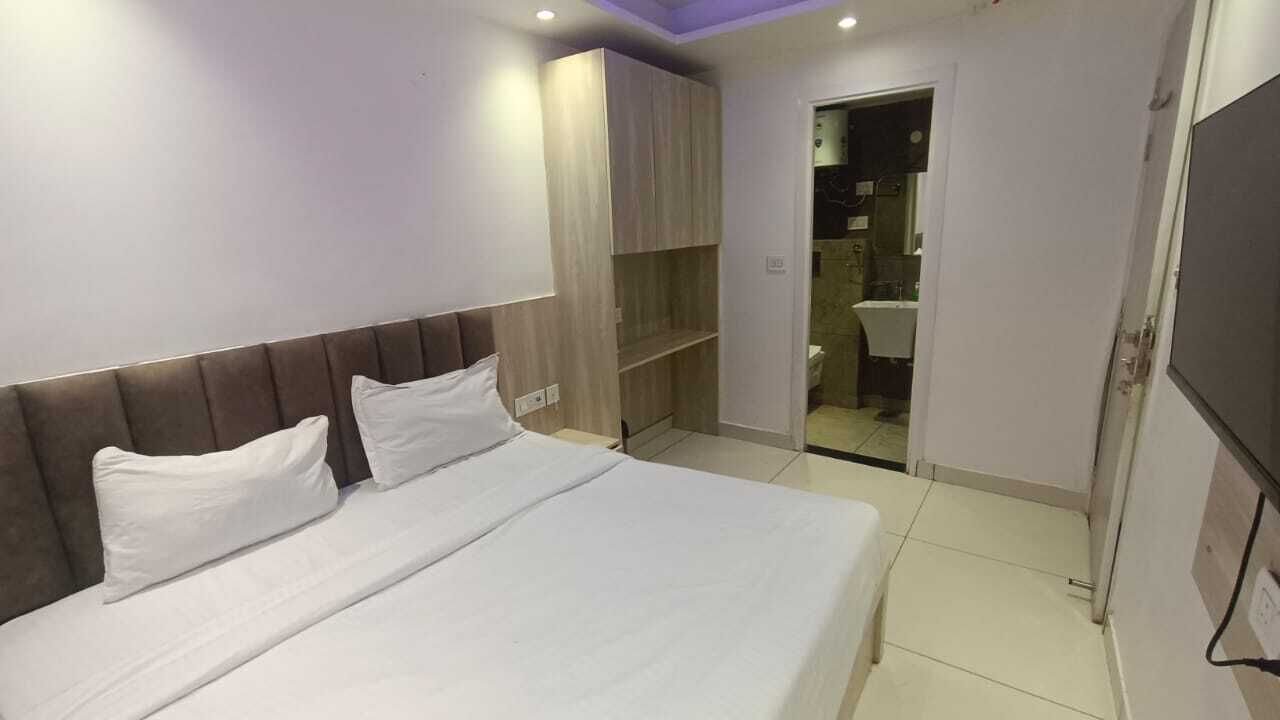 Een hotelkamer met een bed, een kledingkast en een zichtbare badkamer door een open deur.