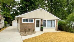 A single-story house with a garage, a small front yard with a mulched area, and a brick exterior. - Amazing 2-bedroom house with AC in Eastlake (Eastlake)