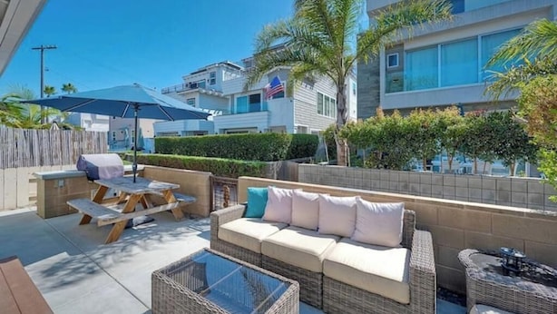 A patio with a wicker sofa, a glass-top table, and a barbecue grill. - 4BR Beach Bungalow - Great for multiple families! (San Diego)