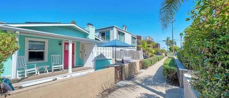 A row of two-story houses with a sidewalk in between.