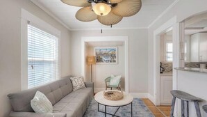A living room with a sofa, a coffee table, and a ceiling fan. - 4BR Beach Bungalow - Great for multiple families! (San Diego)