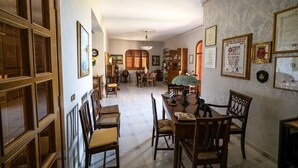 A traditional dining room with wooden furniture, a chandelier, and framed certificates on the walls. - Il rifugio del templare  - Appartamento Cavaliere (Roccavaldina)