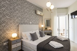 Une chambre bien rangée, avec un lit, une table de chevet et un miroir.