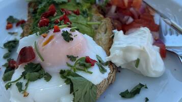 A plate of food with eggs, tomatoes, and greens.