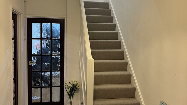 Una escalera con peldaños alfombrados y un candelabro.