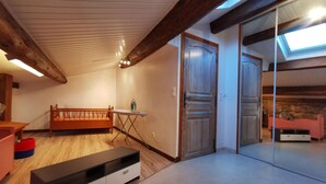 Une pièce spacieuse avec un banc en bois, une petite table et une porte-fenêtre coulissante donnant sur une autre pièce.