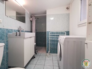 A compact bathroom with a sink, mirror, shower, and a washing machine. - La Saladelle - CANDILLARGUES (CANDILLARGUES)