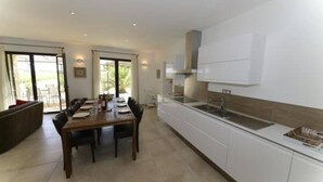 Eine moderne Küche mit weißen Schränken, einem Holzespeisetisch und einem großen Fenster.