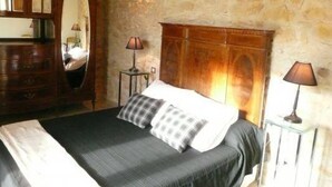 Ein Schlafzimmer mit einem Bett, einem Schminktisch, einem Spiegel und zwei Lampen.