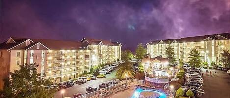 A hotel with multiple buildings, a swimming pool, and a parking lot.