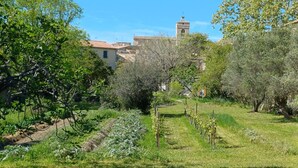 A rural landscape with a tower, trees, and a path.