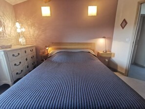 A bedroom with a bed, bedside tables, a dresser, and wall-mounted lights. - Bergerie du Pic Saint-Loup (SAINT-ANDRE-DE-BUEGES)
