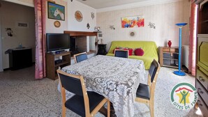 Una sala de estar acogedora con televisor, chimenea y un sofá verde brillante.