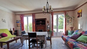 Una sala acogedora con una mesa de comedor, sillas, un sofá y un tapete colorido.