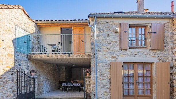 A stone building with a balcony, a dining area, and a door with shutters. - La Bergerie - DIO-ET-VALQUIERES (DIO-ET-VALQUIERES)