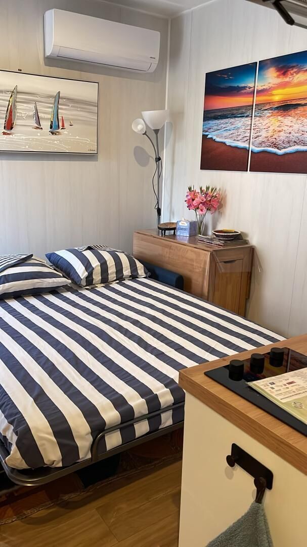 Habitación de hotel con cama, escritorio, silla, lámpara y una obra de arte en la pared.