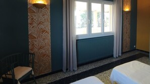 A hotel room with two beds, a window with curtains, a chair, and wall-mounted lights. - Louisiana - SAUVIAN - B&B (SAUVIAN)