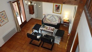 A cozy living room with a fireplace, a dining table, and a sofa. - Le Cabestan - VENDRES (VENDRES)