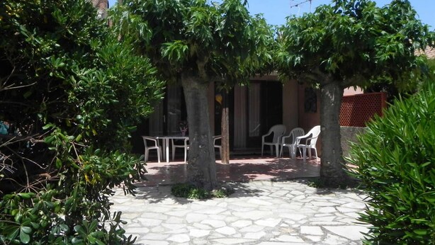 A courtyard with stone flooring, white plastic chairs, and a table. - Le Cabestan - VENDRES (VENDRES)