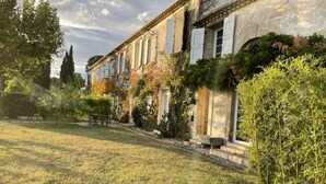 A traditional building with a garden, a bench, and a pathway leading to the entrance. - Côté Cour - MARAUSSAN - Gîte (MARAUSSAN)