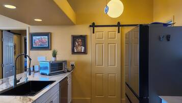 A compact kitchen with a sink, a microwave, and a refrigerator.