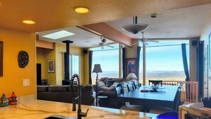 Una cucina moderna con una grande isola, un'area pranzo con vista e un soggiorno con divano e lampada.