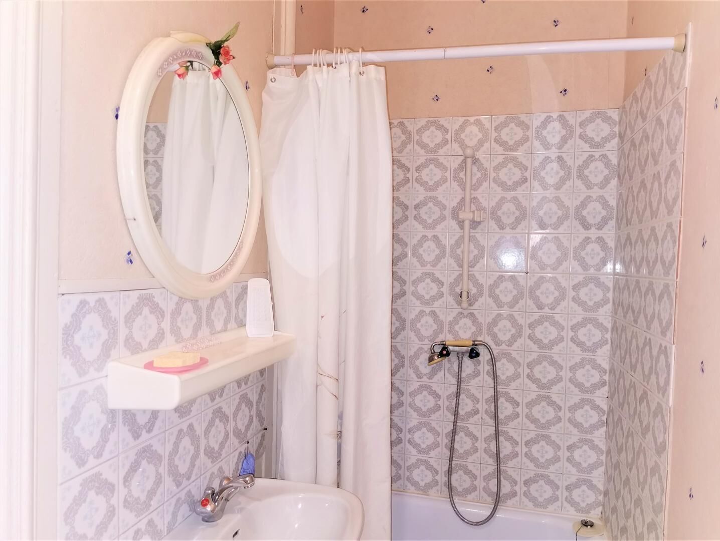Ein Badezimmer mit Dusche, Waschbecken und Spiegel.