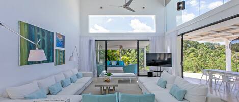 A modern living room with white sofas, a coffee table, and artwork on the walls.