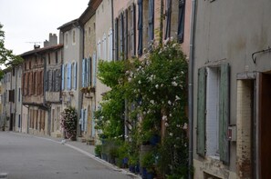 Eine schmale Straße gesäumt von historischen Gebäuden mit traditioneller Architektur und Fensterläden.