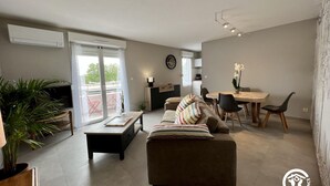 Una sala de estar moderna con sofá, una mesa de centro y un comedor con sillas y una mesa.