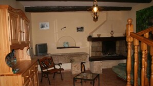 A cozy living room with a fireplace, wooden furniture, and a tiled floor. - Domaine du Coude - SAINT ANDRE DE ROQUELONGUE (SAINT ANDRE DE ROQUELONGUE)