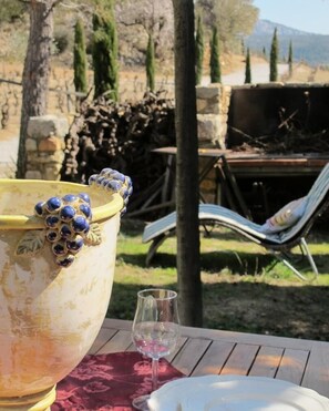 A table with a large decorative pot, a glass, and a white plate.