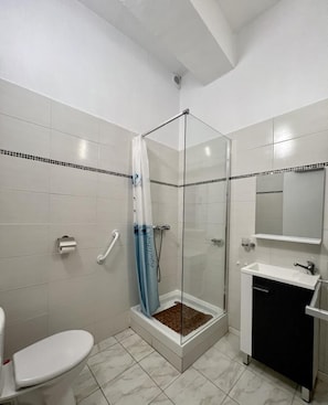 Ein Badezimmer mit Dusche, Toilette und Waschbecken.