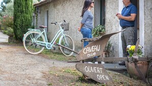 A rustic building with a sign indicating 'CAVEAU CELLAR' and 'OUVERT OPEN'.