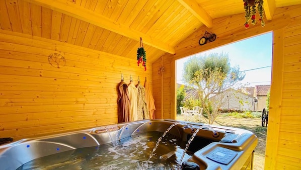 Una cabaña de madera con jacuzzi, paredes de madera y vistas al exterior.