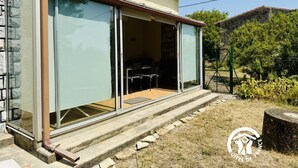 Una casa con una porta in vetro che si apre su un portico coperto.