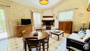 Een gezellige woonkamer met een open haard, houten meubels en een televisietoestel.