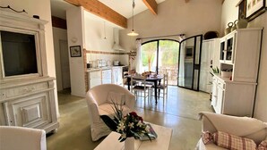 Un salón amplio con chimenea, comedor y cocina.